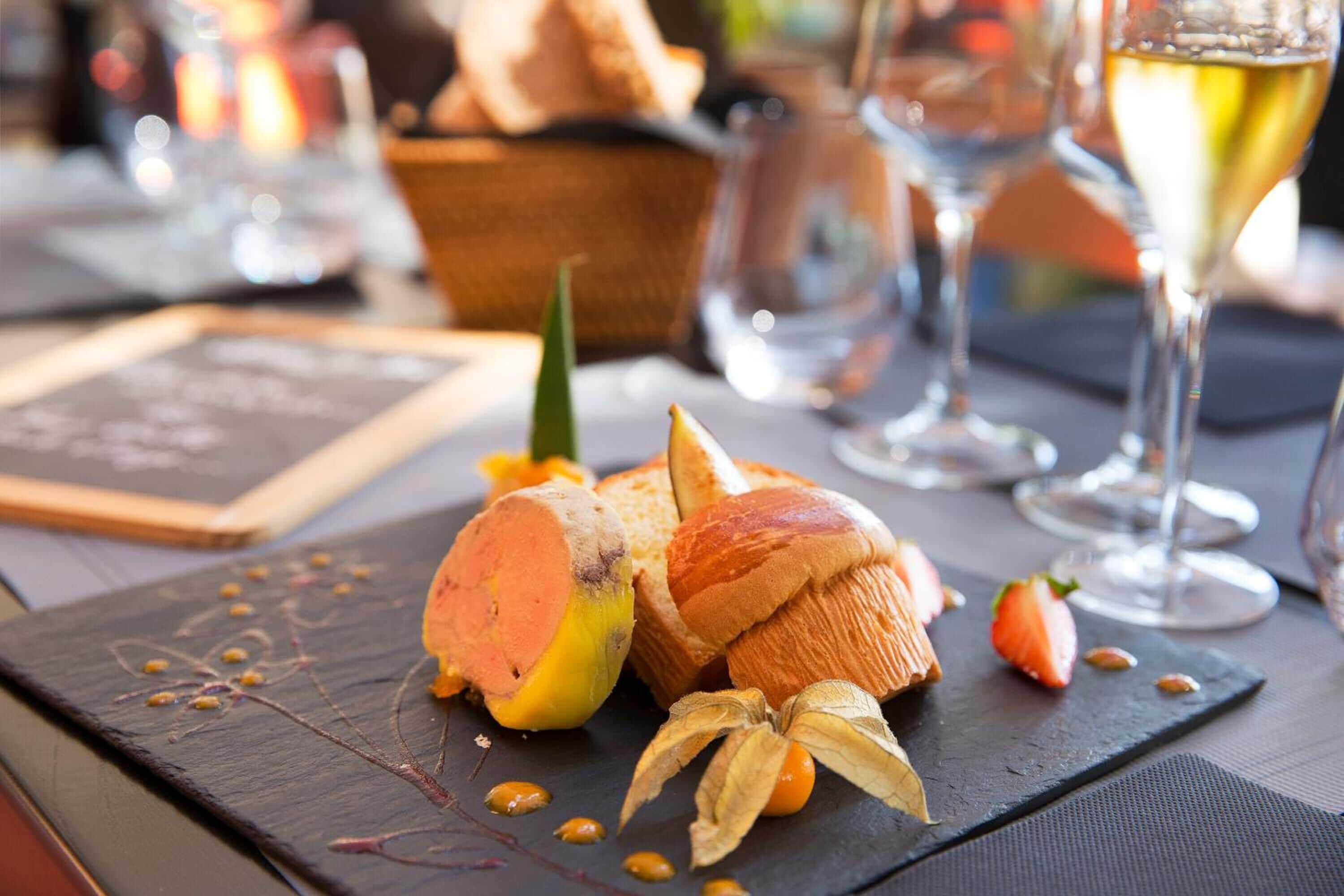A dessert plate with a sweet potato, bread, and a banana on a slate board.