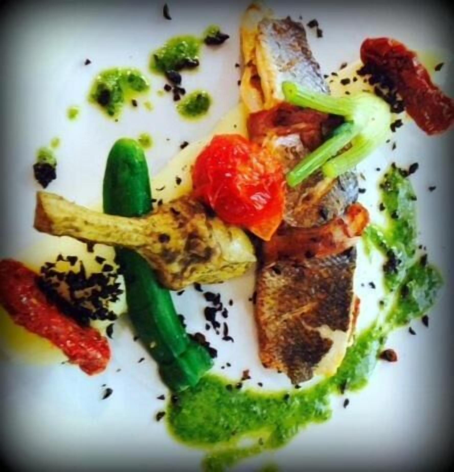 Plat de menjar amb verdures a la planxa i una salsa verda.