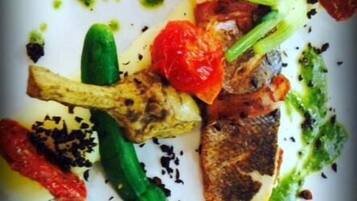 Plat de menjar amb verdures a la planxa i una salsa verda.