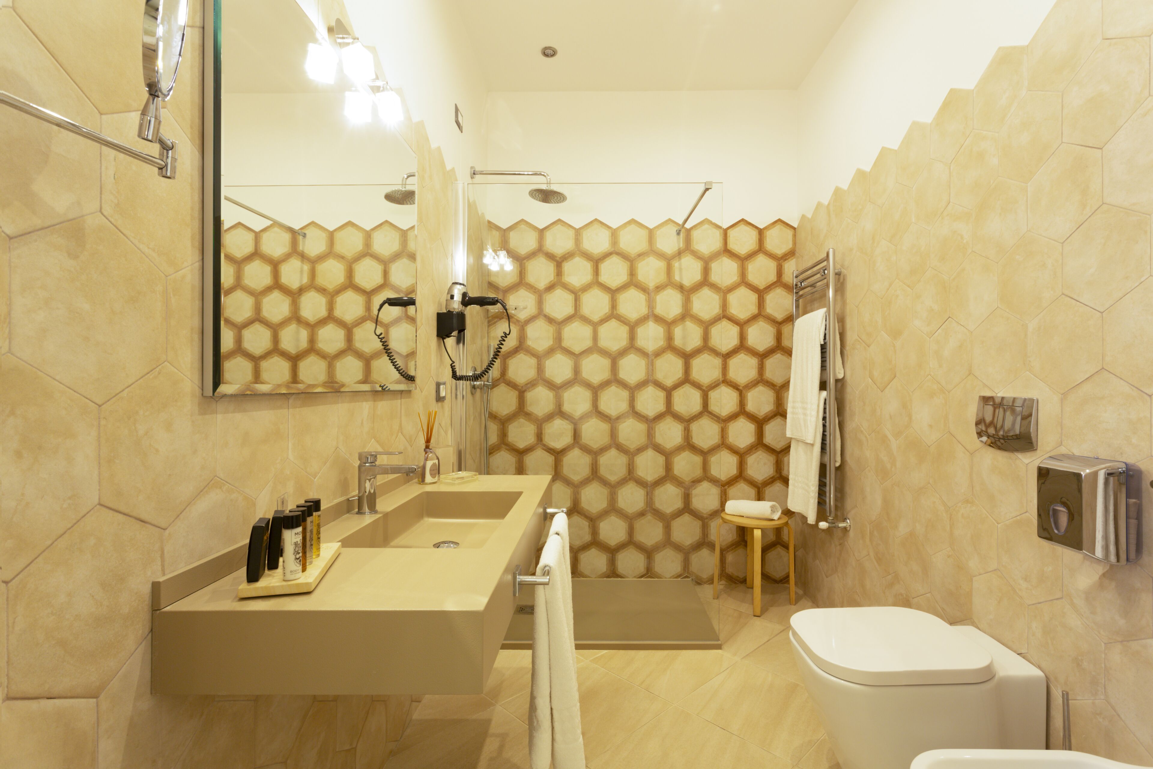 A modern bathroom with a large sink, a toilet, and a shower area.