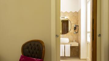 A doorway leading to a bathroom with a sink, mirror, and towel rack.