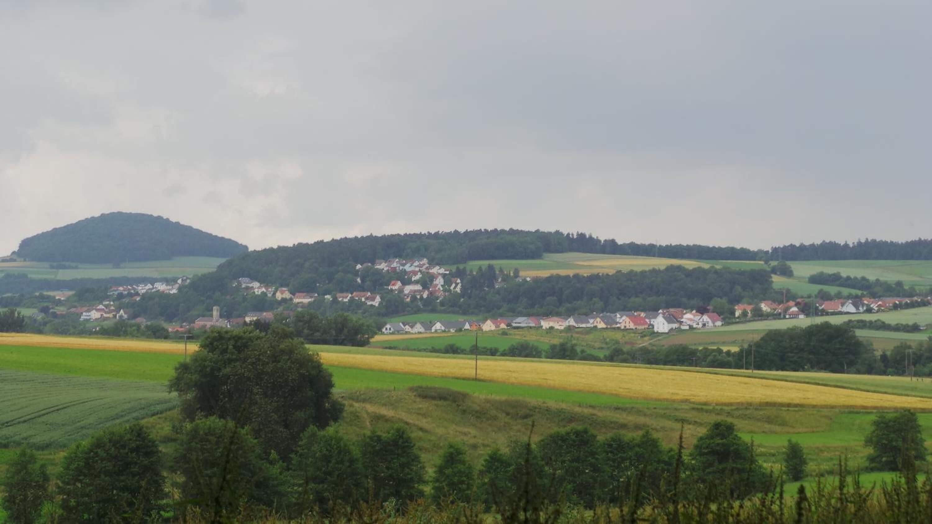 A rural landscape with a village and fields.