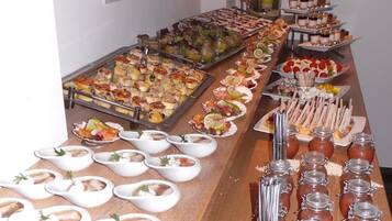 Una mesa de buffet con diversos alimentos, como mariscos, postres y salsas.