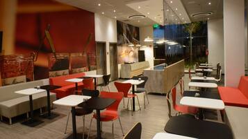 A modern restaurant interior with booths and tables, a counter, and a view of the outside.