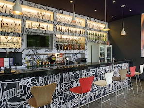 A bar area with a counter, shelves of bottles, and bar stools. - ibis Itatiba (Itatiba)