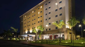 A multi-story hotel with a prominent 'ibis HOTEL' sign, a covered entrance, and a well-lit facade. - ibis Itatiba (Itatiba)