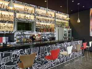 A bar area with a counter, shelves of bottles, and bar stools. - ibis Itatiba (Itatiba)