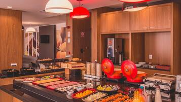 A buffet area with various food items and a coffee machine.