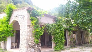 A rustic stone building with arched doorways and a covered patio area. - Agriturismo Colloreto (Morano Calabro)