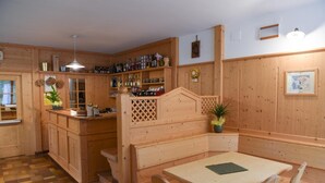 Un interior de fusta amb una zona de bar, seients i una taula de dinar.