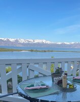 Una mesa de comedor con vistas a montañas nevadas al otro lado de un lago.
