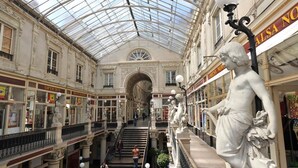 An indoor shopping mall with a glass ceiling, ornate columns, and statues. - Hotel Saint Daniel (Nantes)