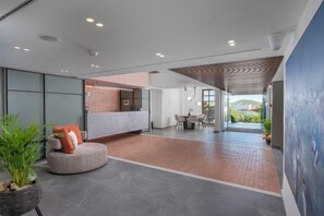 A spacious lobby with a reception desk, seating area, and a view of the outdoors. - Alkyon (Skiathos)