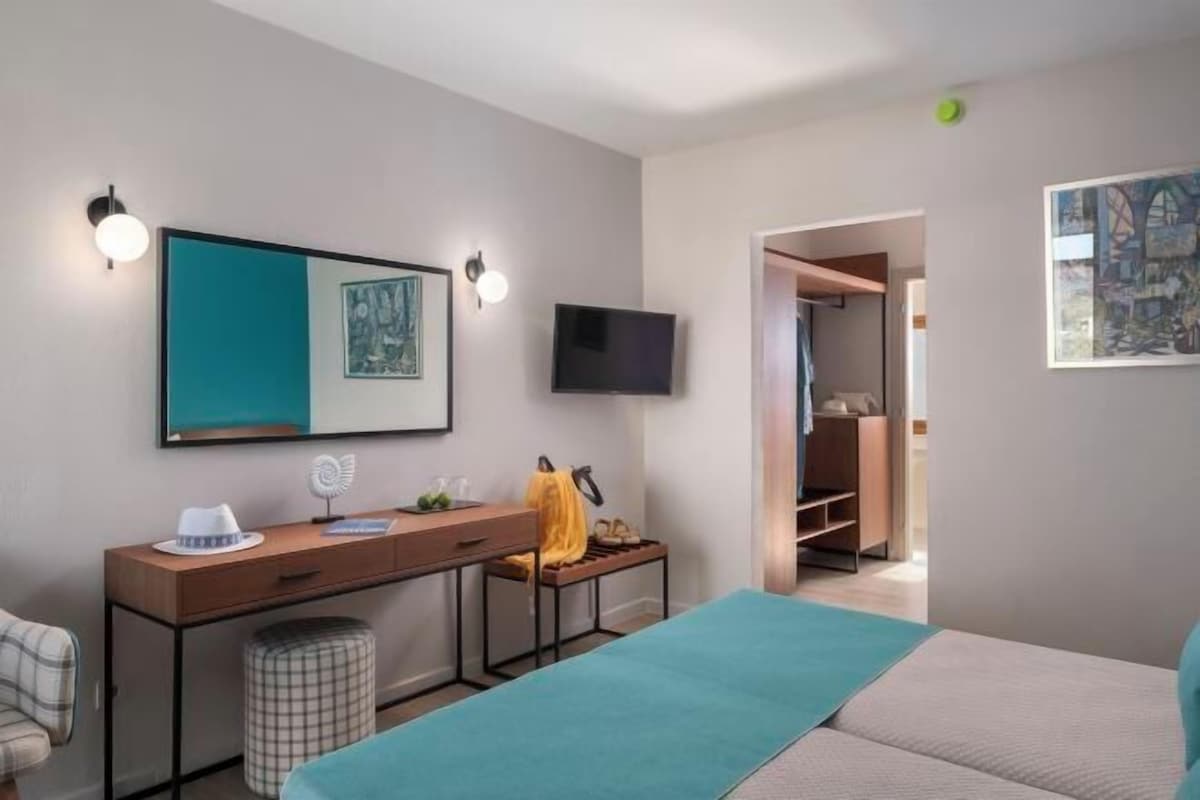 Ein modernes Schlafzimmer mit Bett, Nachttisch und Fernseher.