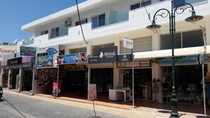 Straßenansicht mit Geschäften, darunter ein Tätowierstudio, ein Juwelier und ein Bekleidungsgeschäft.