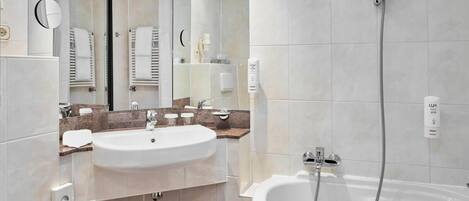 A modern bathroom with a large sink, mirror, and a separate shower area.