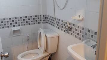 A bathroom with a toilet, sink, and tiled floor.