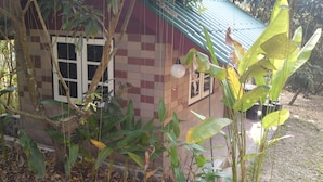 A small house with a tiled exterior, a window, and a door. - Suanrimtarn Suanphung (Suan Phueng)