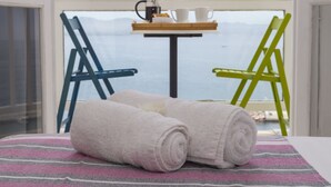 A balcony with a table, two chairs, and a view of the sea. - Galini Mare (Agios Vasileios)
