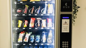A vending machine with various snacks, drinks, and a payment interface.