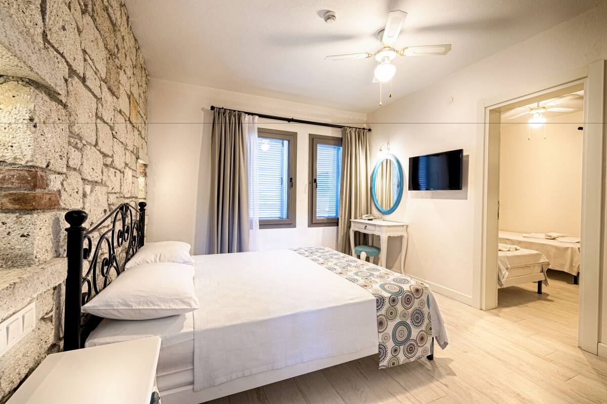 Een slaapkamer met een bed, een bureau, een spiegel en een televisie.