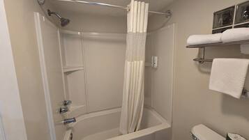 A bathroom with a shower, toilet, and towel rack.