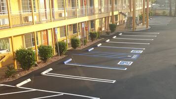 Un motel de varios pisos con un estacionamiento señalizado para personas con discapacidad.