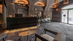 A modern interior with a reception desk, seating area, and large windows.