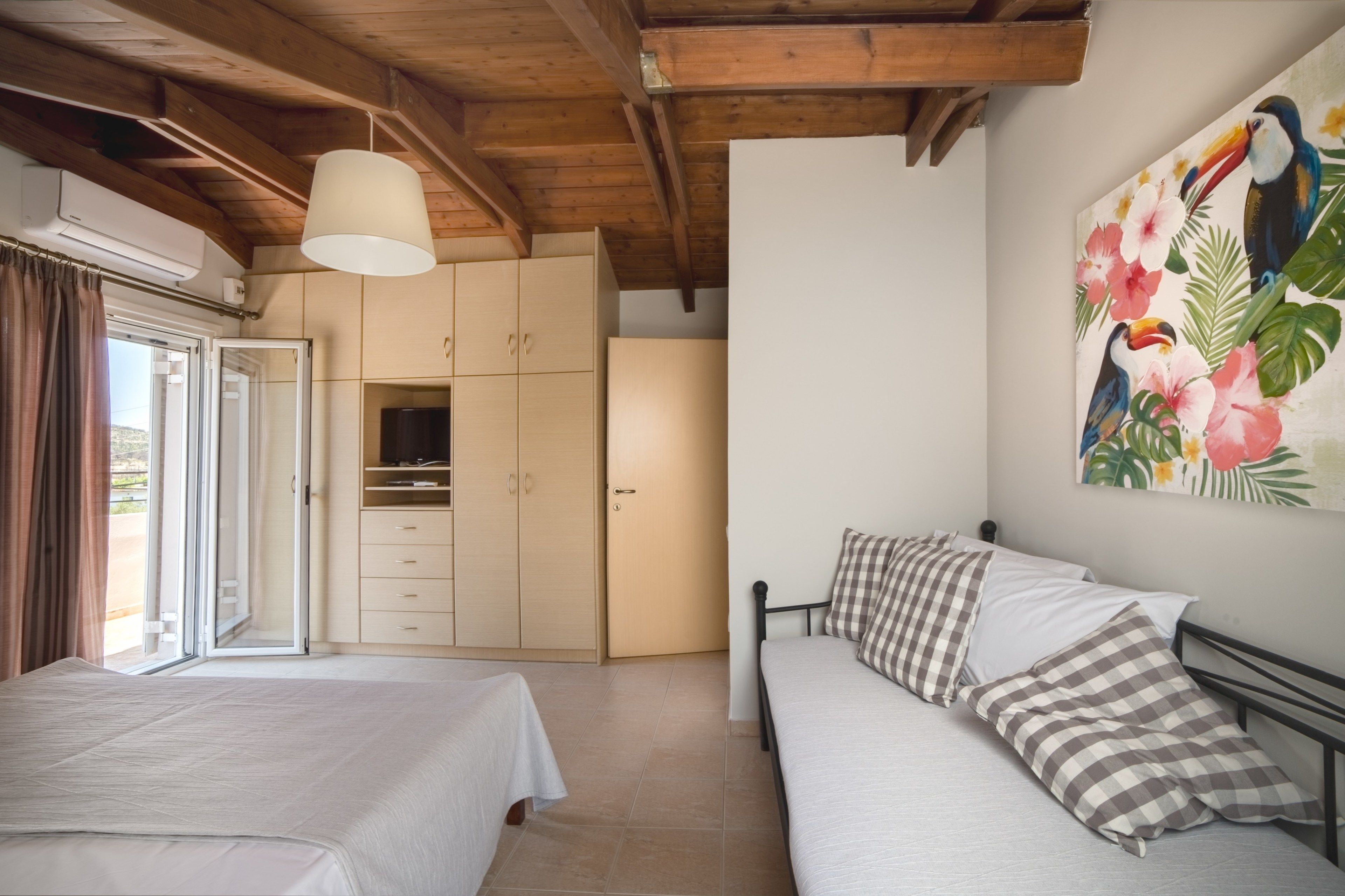 Une chambre avec deux lits, une armoire et un tableau au mur.
