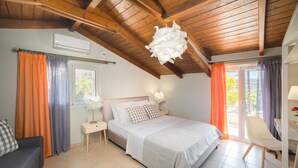 Un dormitorio con cama, una silla, una mesita de noche y una ventana con cortinas.