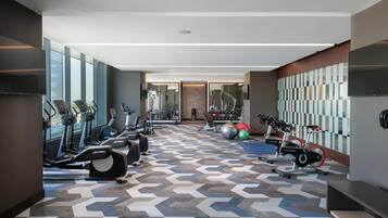 Un gimnasio moderno con cintas de correr, elípticas y pelotas de ejercicio.