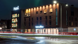 Un hotel con fachada de ladrillo moderno, señalización iluminada y una señal de paso de peatones.
