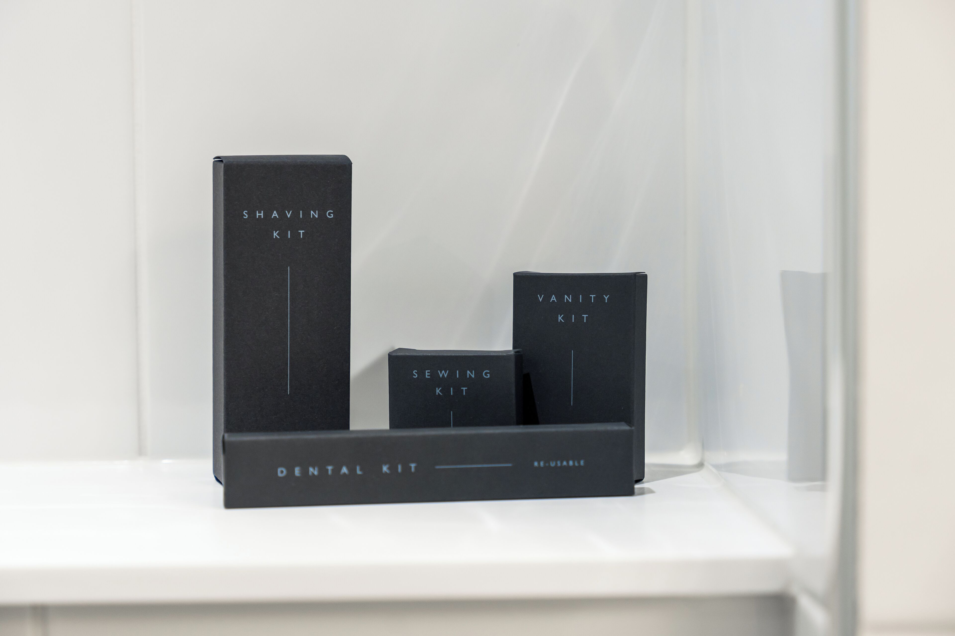A dental kit with a shaving kit and a vanity kit on a white shelf.