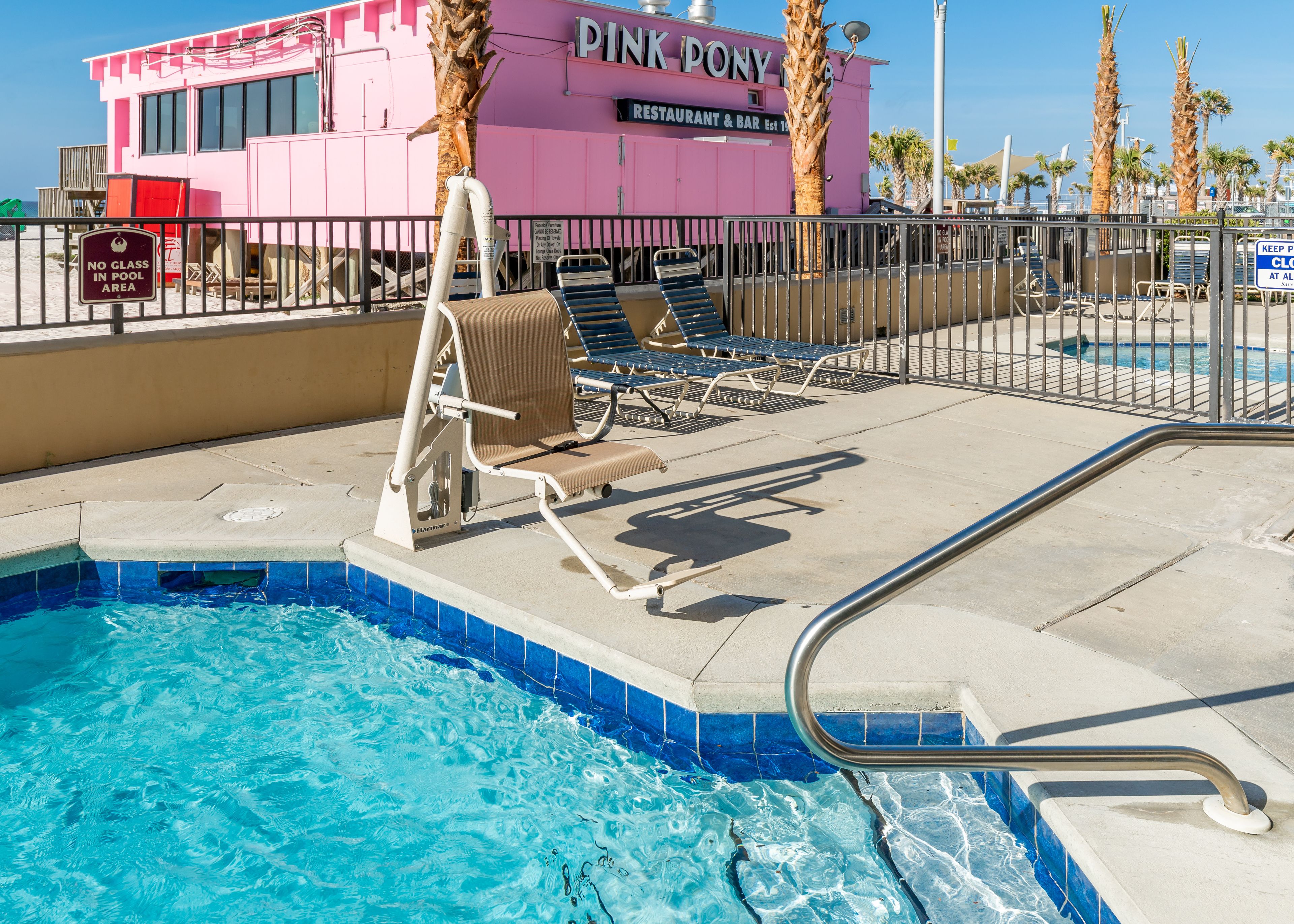 A pool area with lounge chairs and a lifeguard tower.