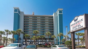 A multi-story hotel with a prominent sign for the Phoenix Hotel. - Phoenix All Suites (Gulf Shores)