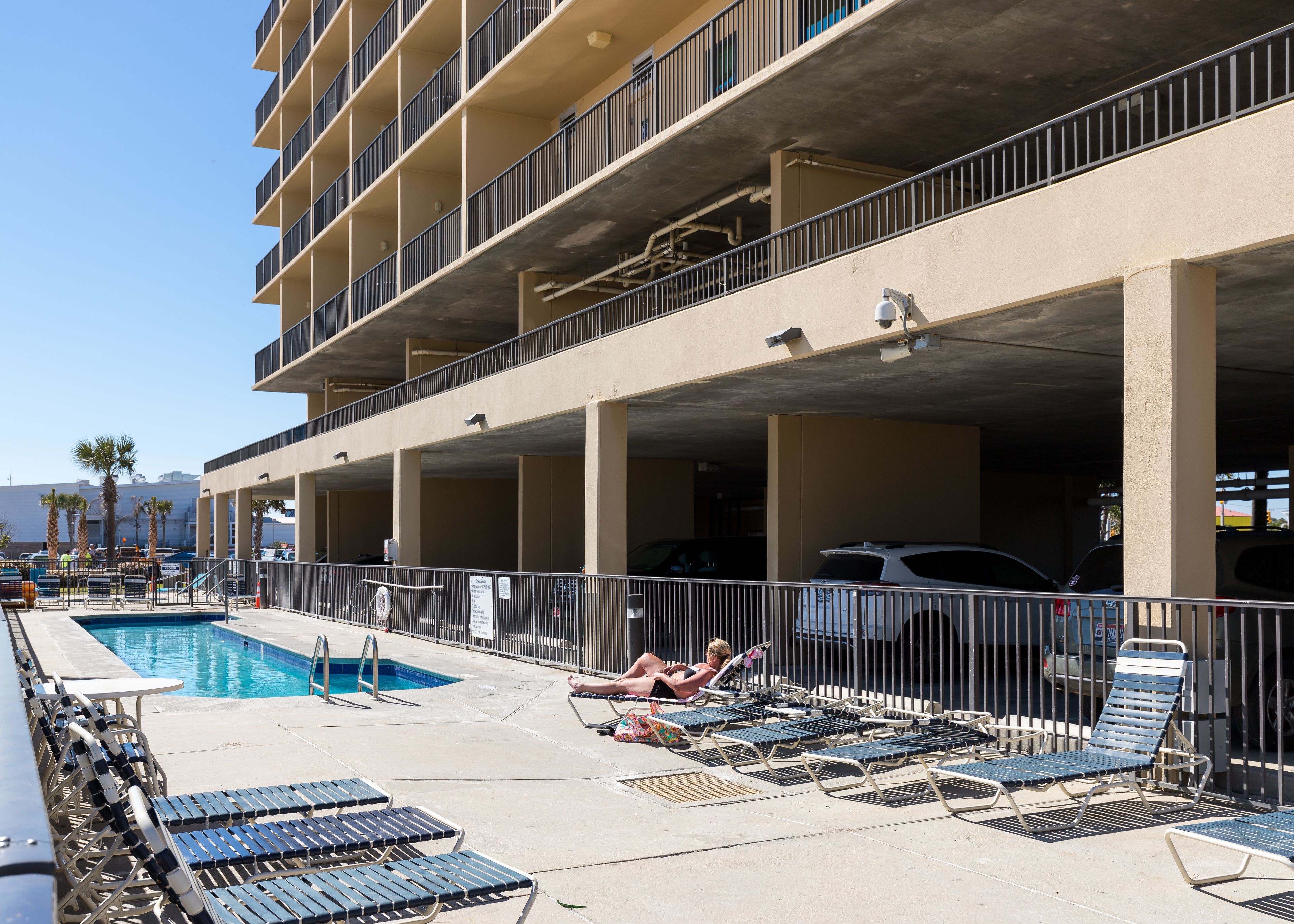 A rooftop pool area with lounge chairs and a swimming pool.
