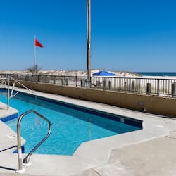 Enjoy a refreshing swim in the pool surrounded by a spacious deck and access to the sandy beach.