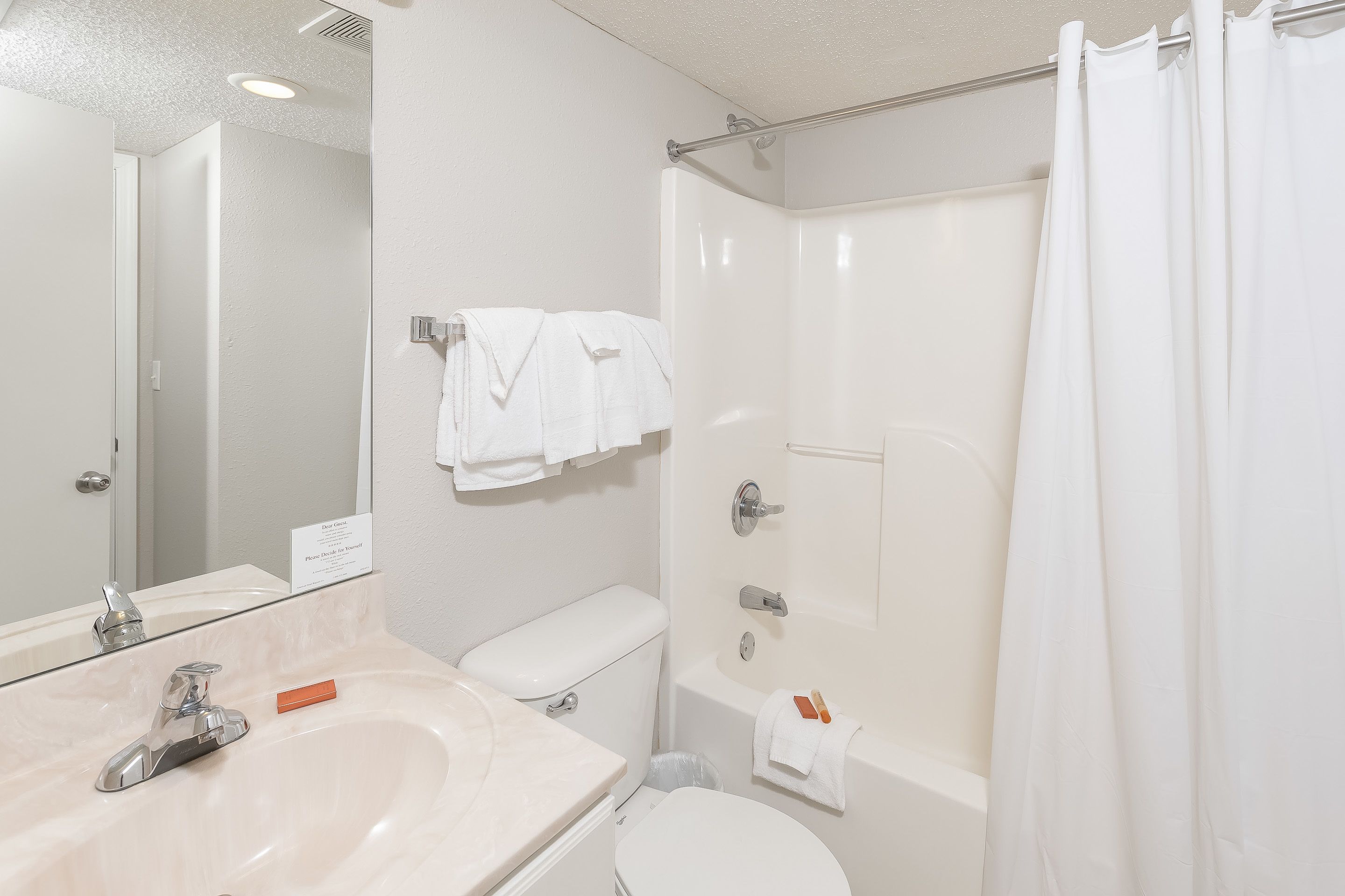 A bathroom with a sink, toilet, and shower.