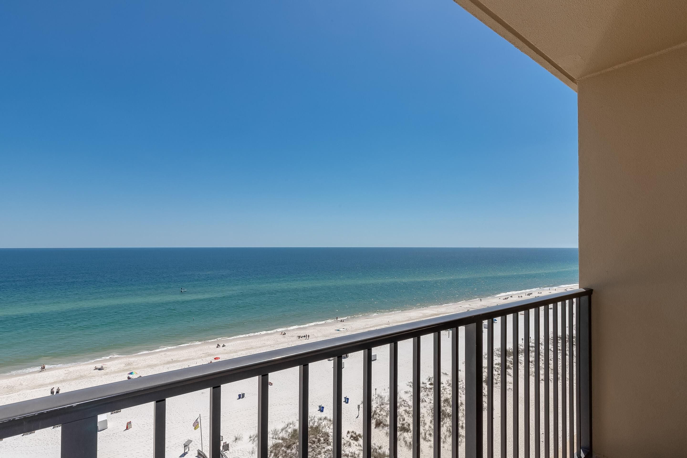 A balcony with a view of a beach and ocean.