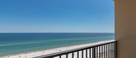 A balcony with a view of a beach and ocean.