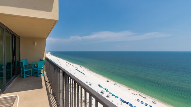 Ein Balkon mit Blick auf Strand und Meer.