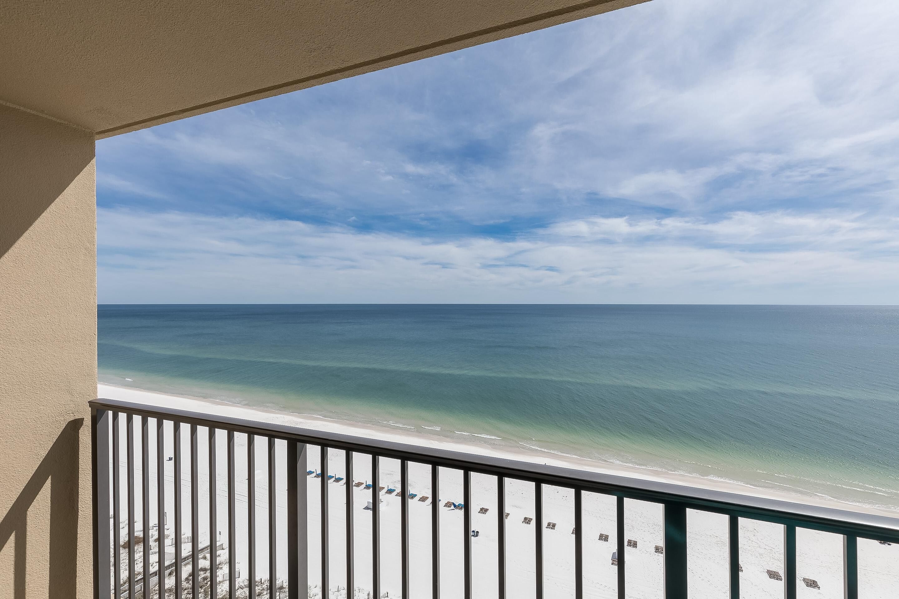 A balcony with a view of a beach and ocean.
