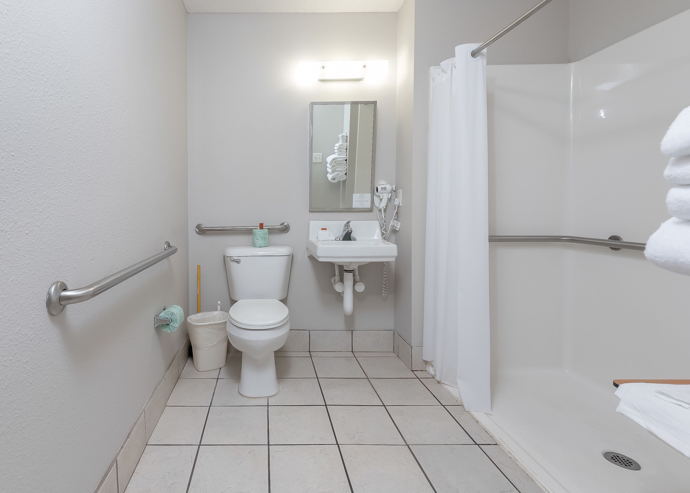 A bathroom with a toilet, sink, and shower.