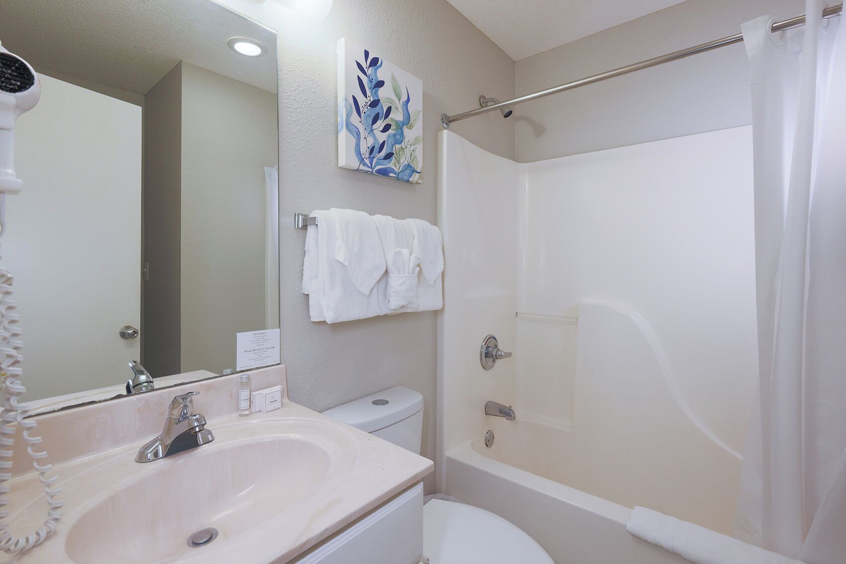 A bathroom with a sink, toilet, and shower.