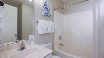 A bathroom with a sink, toilet, and shower.