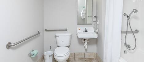 Et badeværelse med toilet, vask og bruser.