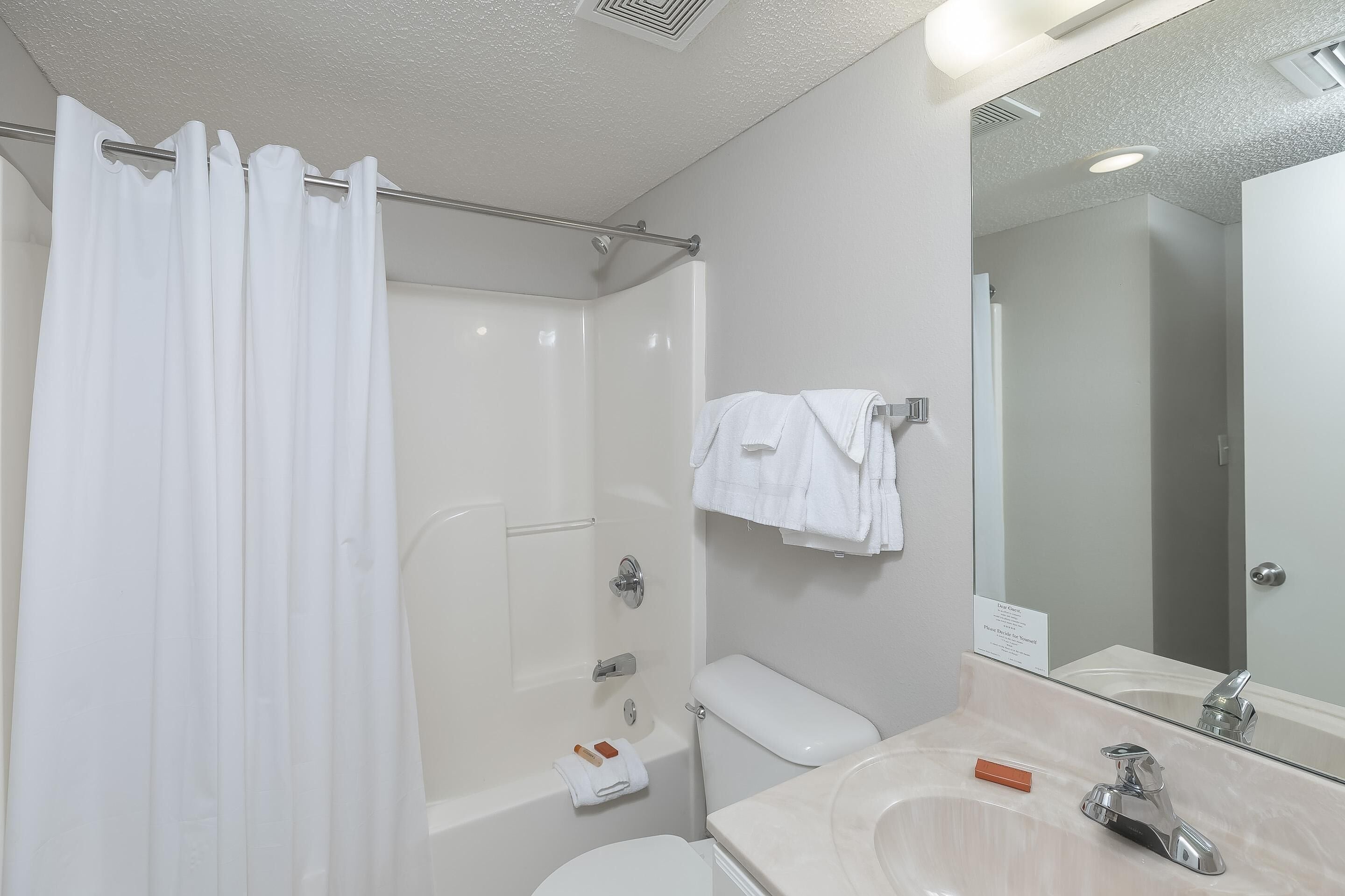 A bathroom with a shower, toilet, and sink.