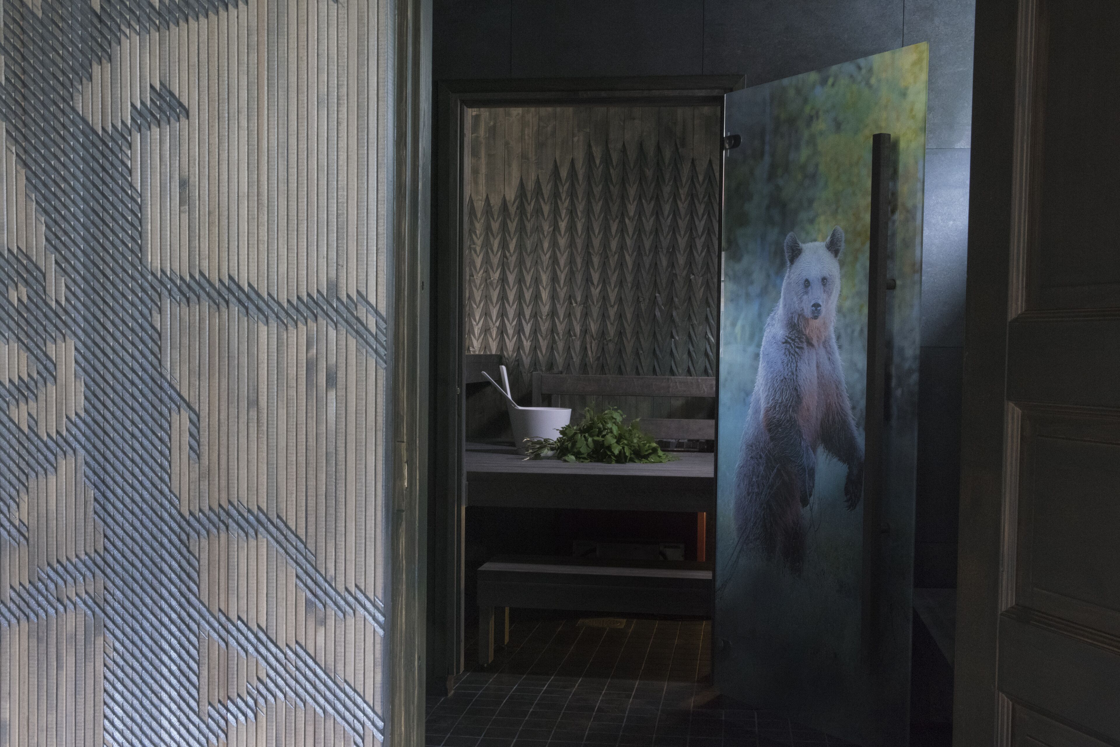 Et moderne køkken med en træ-hak backsplash, en hvid vask og et stålskab med et billede af en bjørn.