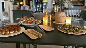 Een buffet met diverse gerechten, waaronder zeevruchten, salades en voorgerechten, in een goed verlichte ruimte.