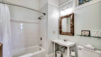 Un baño con bañera, lavamanos, inodoro y ducha.